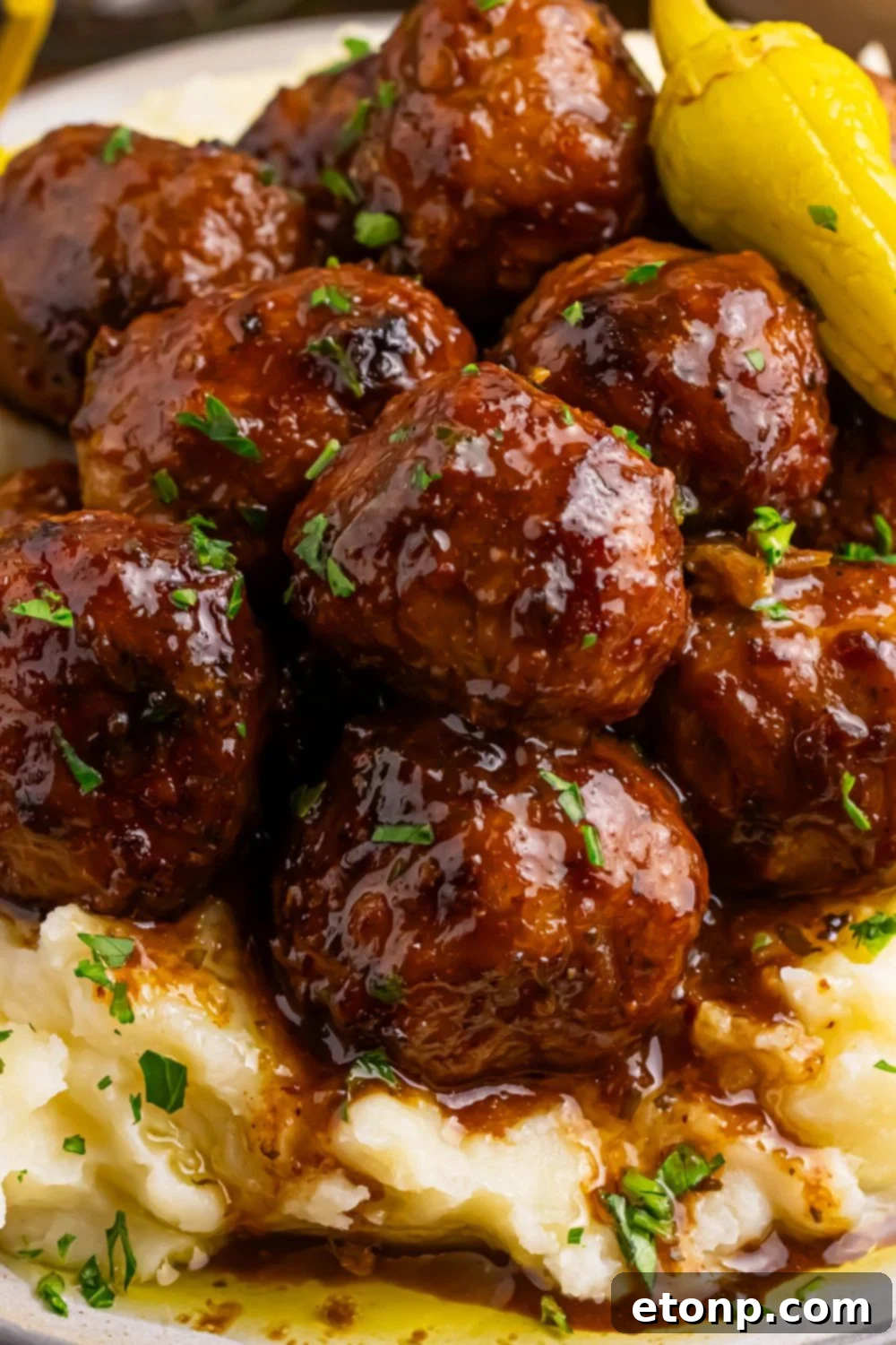 5 Ingredient Crockpot Mississippi Meatballs 8 close up of Crockpot Mississippi Meatballs on plate with mashed potatoes under the meatballs