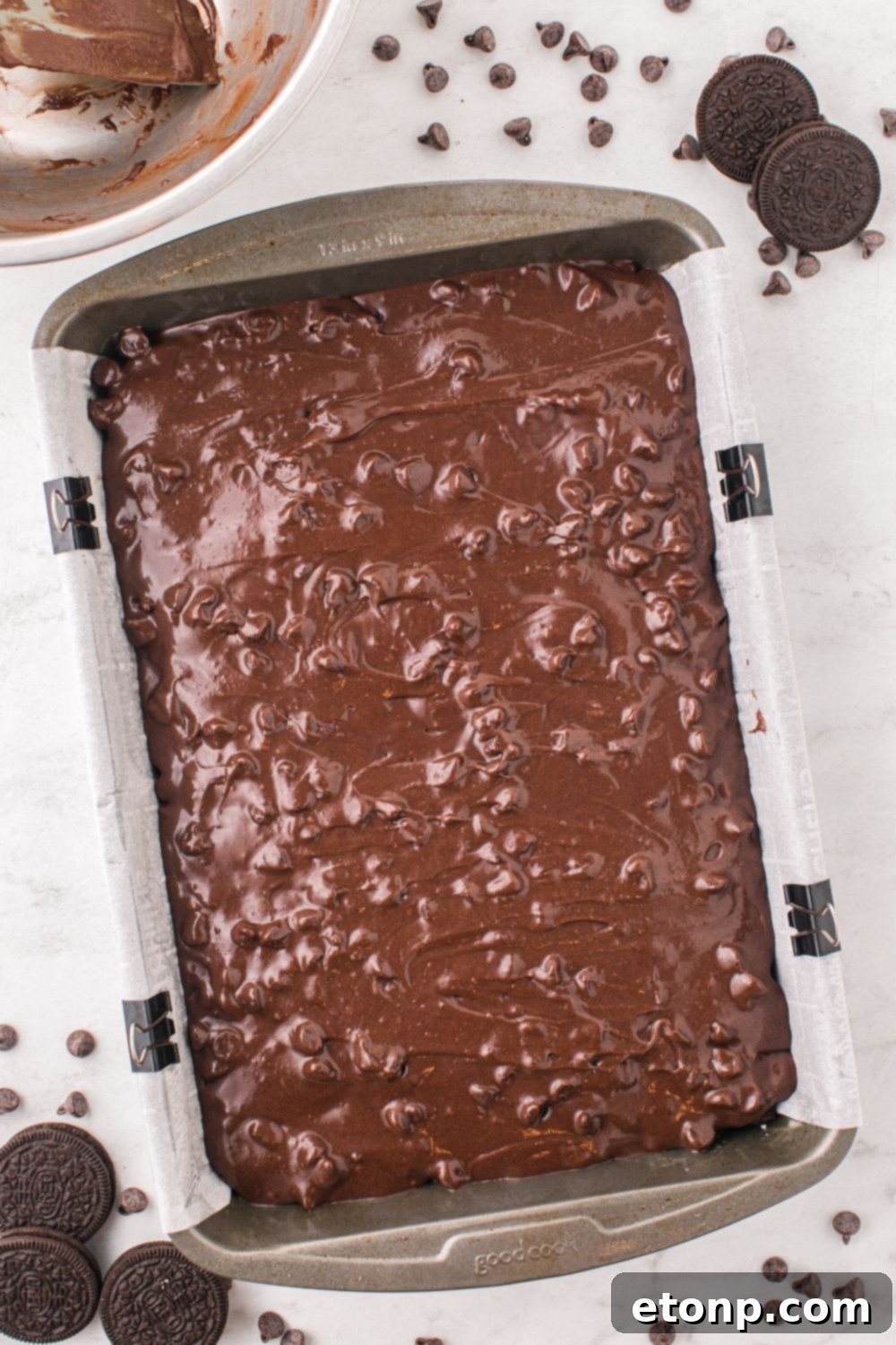 raw brownie batter in pan with chocolate chips on top 