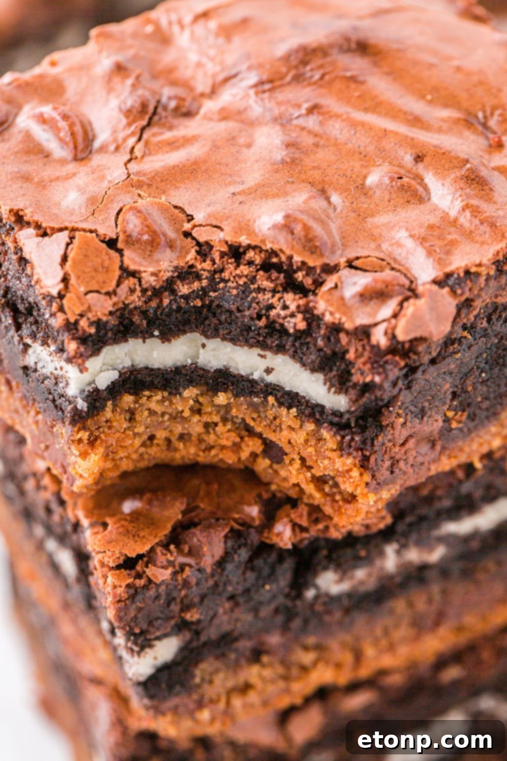 Slutty Brownies stacked on top of one another with a bite taken out of one brownie