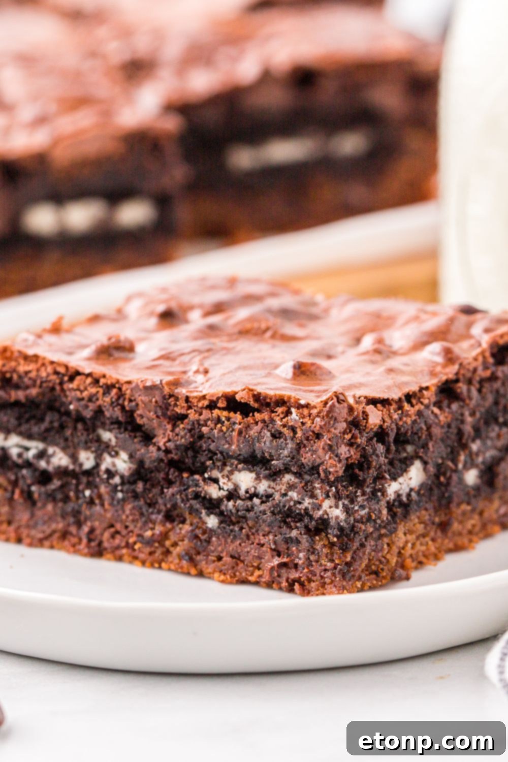 Slutty Brownies sliced on a tray and a plate with cookies on plate with a glass of milk