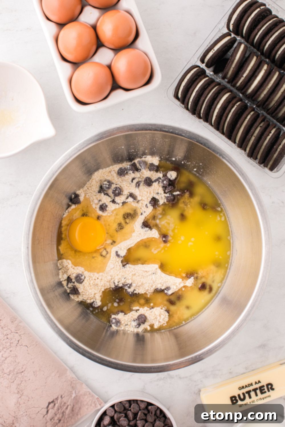 mixing bowl with chocolate chip cookie dough in a bowl with cookies and eggs 