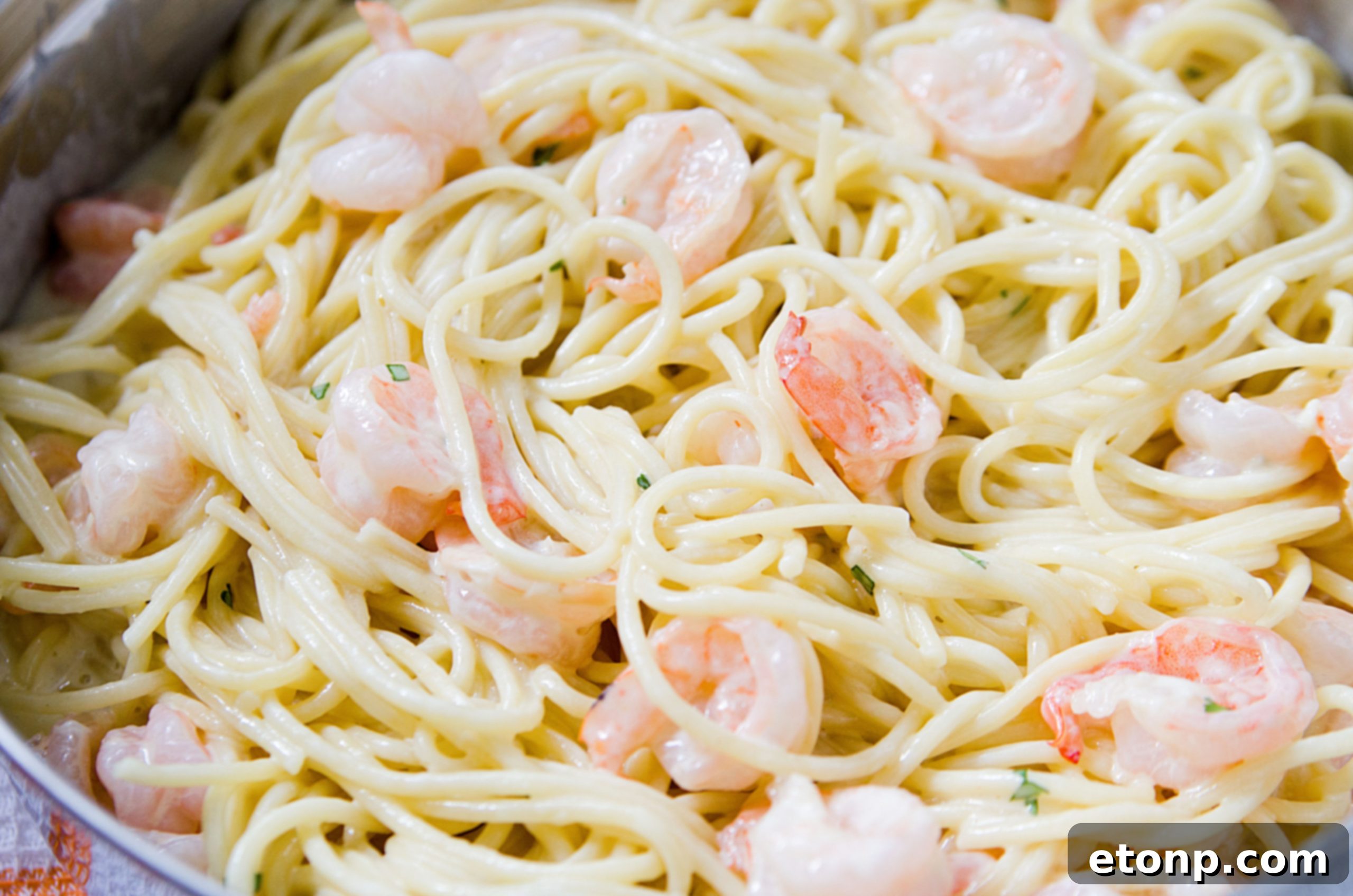 A large serving of Four Cheese Garlic Shrimp Pasta in a rustic bowl, highlighting the generous amount of melted cheese and shrimp.