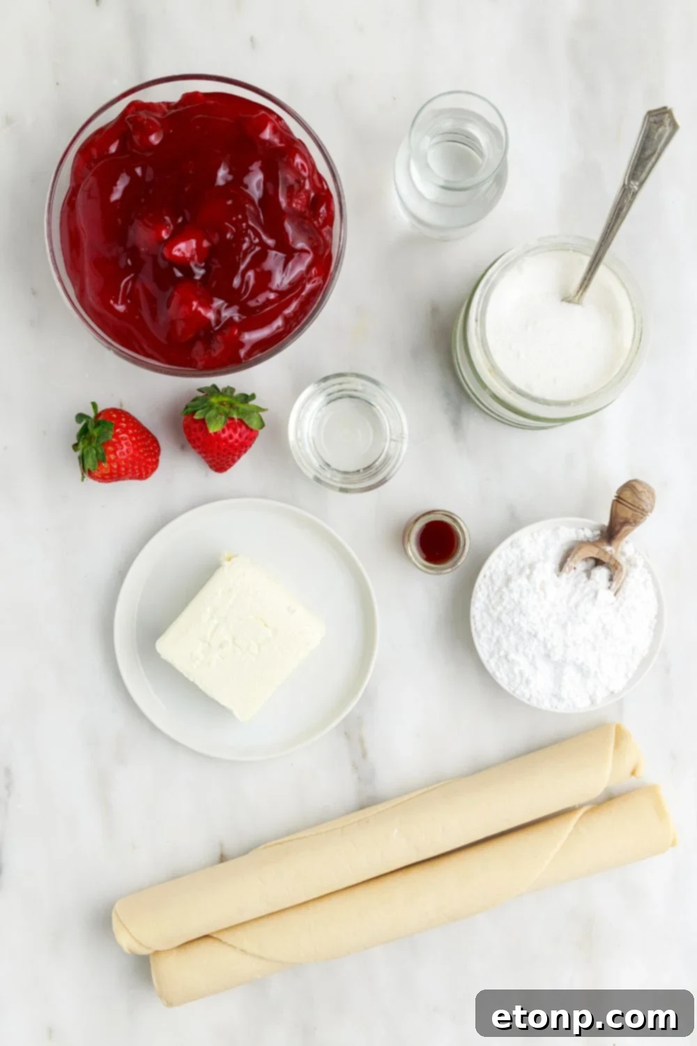 Individual ingredients for Deep Fried Strawberry Cheesecake Pies displayed on a table in single-serve containers, ready for preparation.