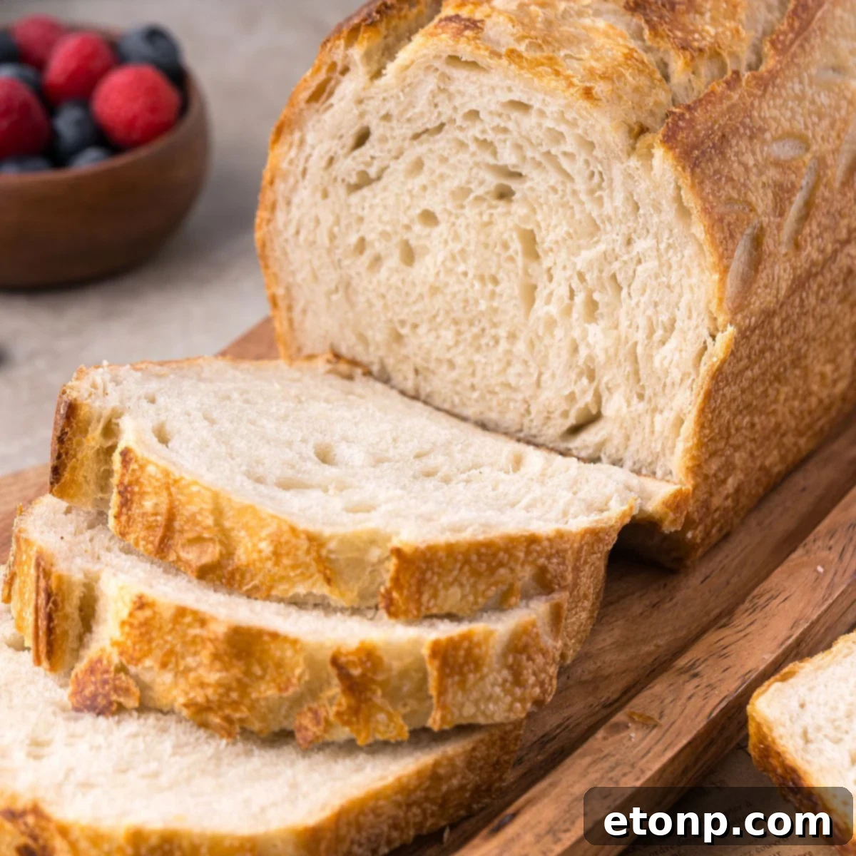 Homemade Sourdough Bread on cutting board with a few slices cut out of the loaf of bread 