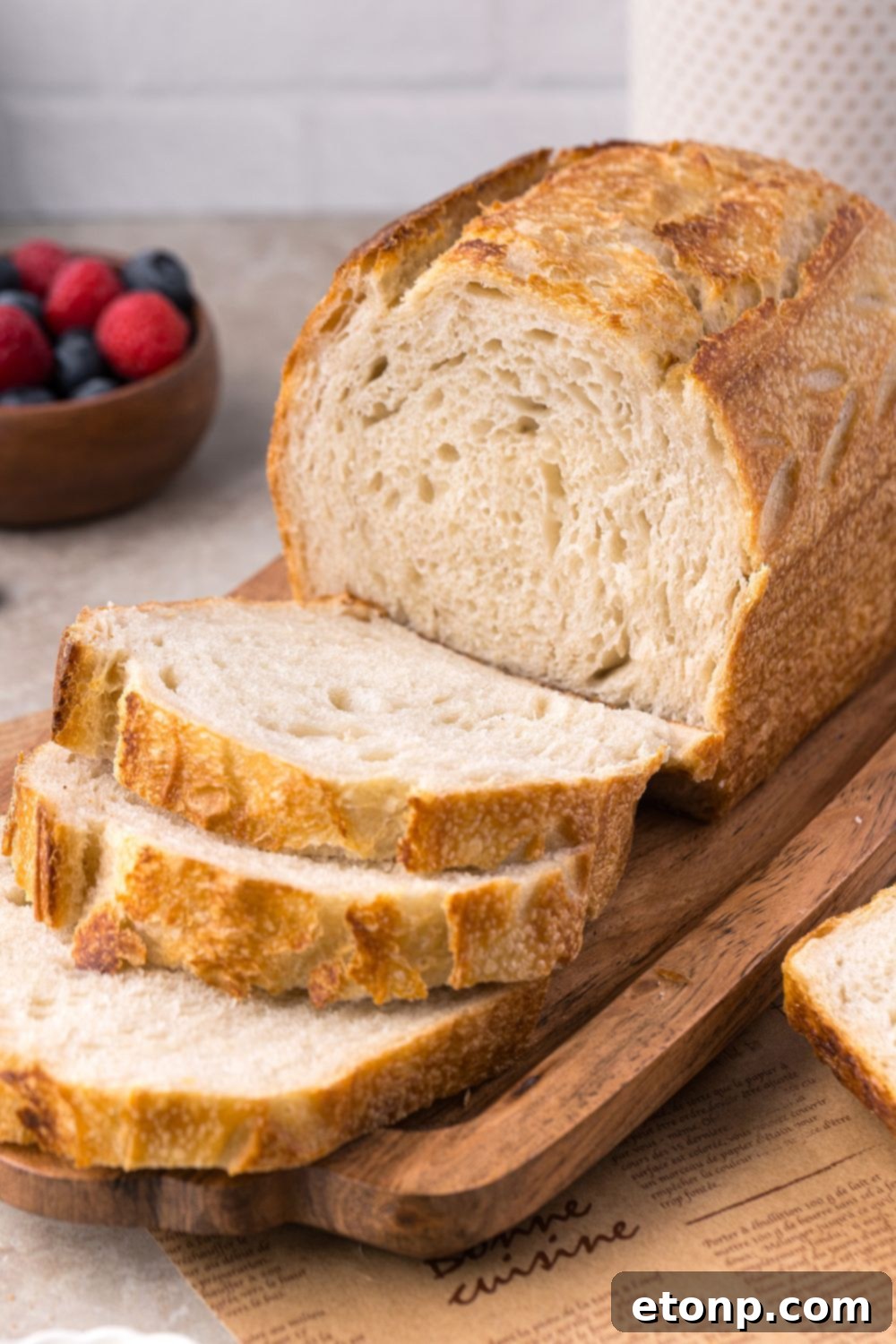 Homemade Sourdough Bread on a tray on table with some of the bread sliced to show the texture 