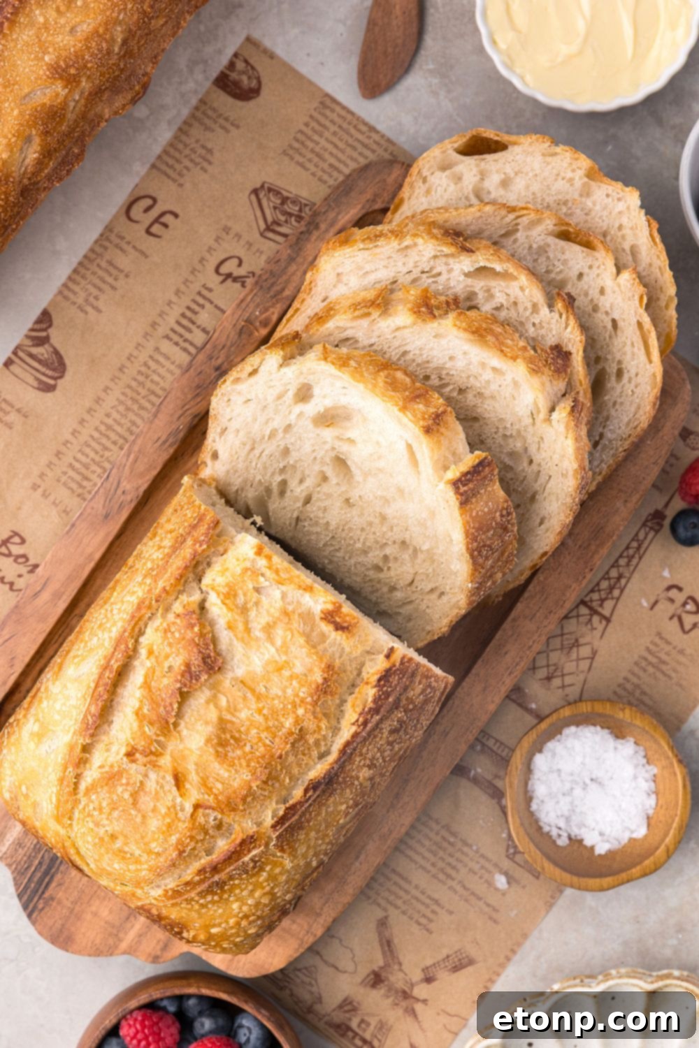 Homemade Sourdough Bread sliced on tray with some butter and salt in small bowls to side