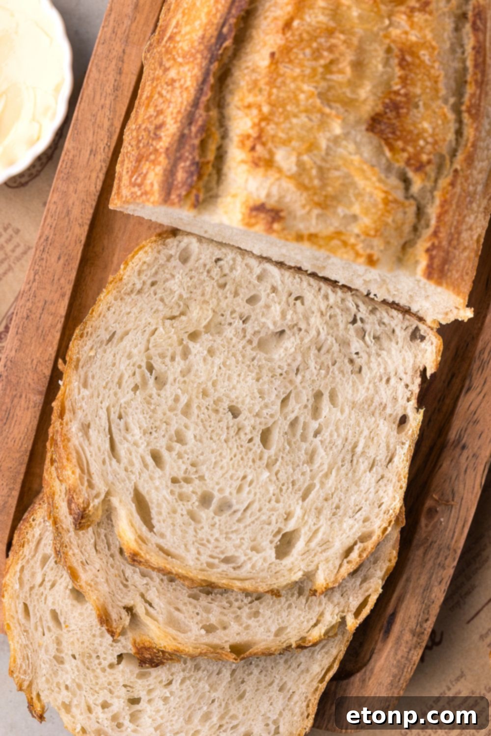 Homemade Sourdough Bread on cutting board with half the loaf sliced in sandwich slices 