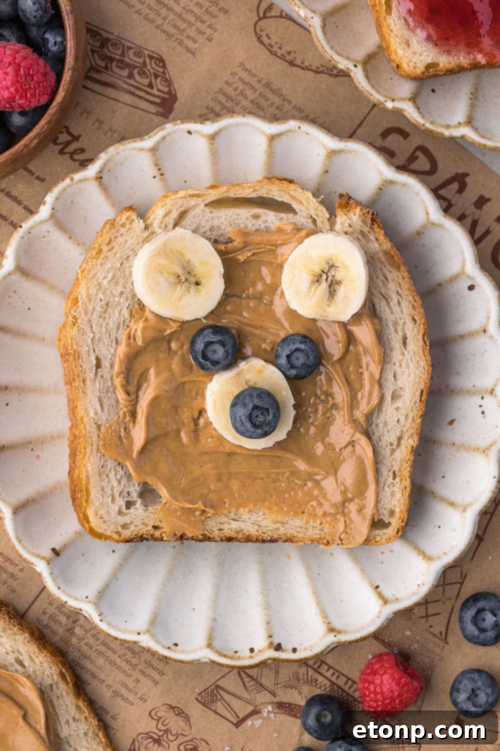 sourdough bread decorated to look like a bear with peanut butter, bananas, and blueberries 