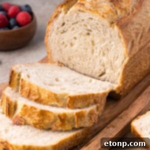 Homemade Sourdough Bread on cutting board with a few slices cut out of the loaf of bread