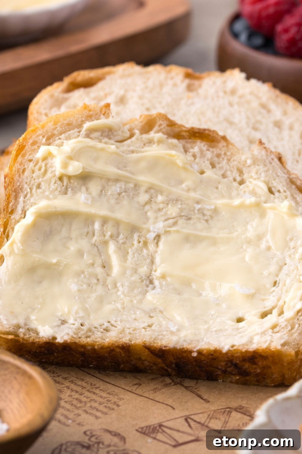 sliced Homemade Sourdough Bread with butter on top of the bread sitting on table 