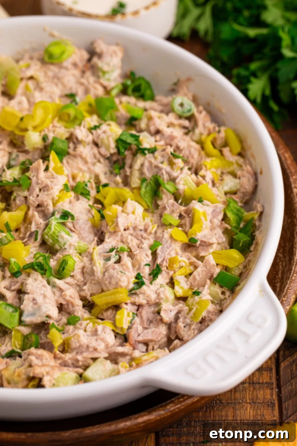 Pepperoncini Ranch Tuna Salad on a table with fresh herbs and salt and pepper shakers