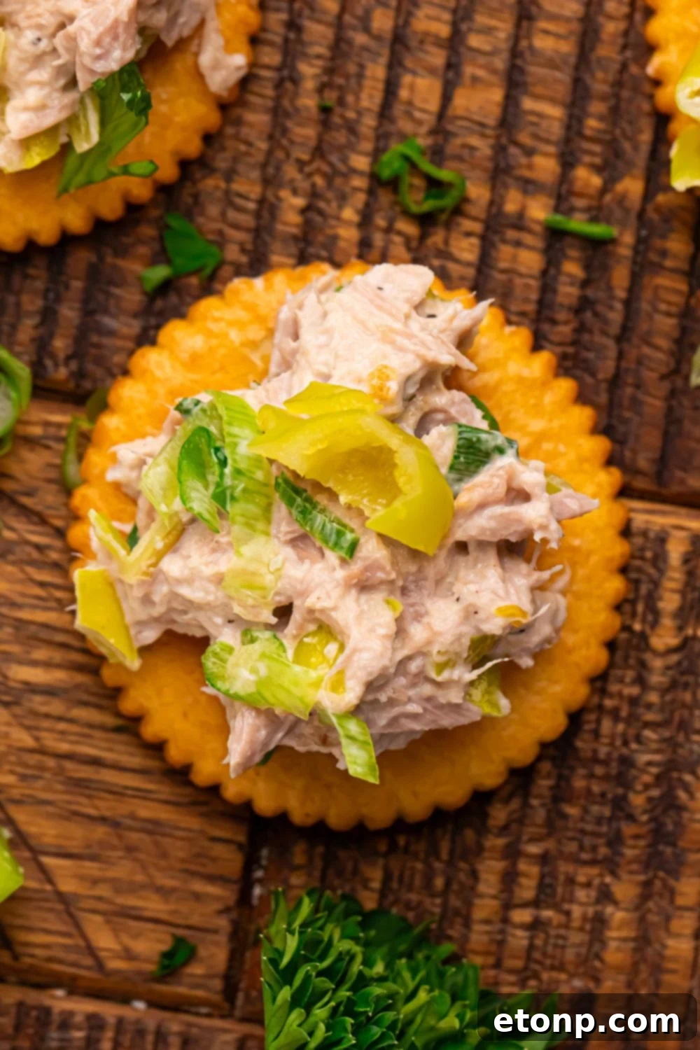 Pepperoncini Ranch Tuna Salad on top of a Ritz cracker, sitting on a wooden table