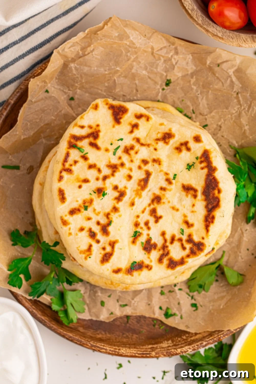 overhead look at table with a stack of 3 Ingredient Flatbread on it with parchment paper crinkled on table