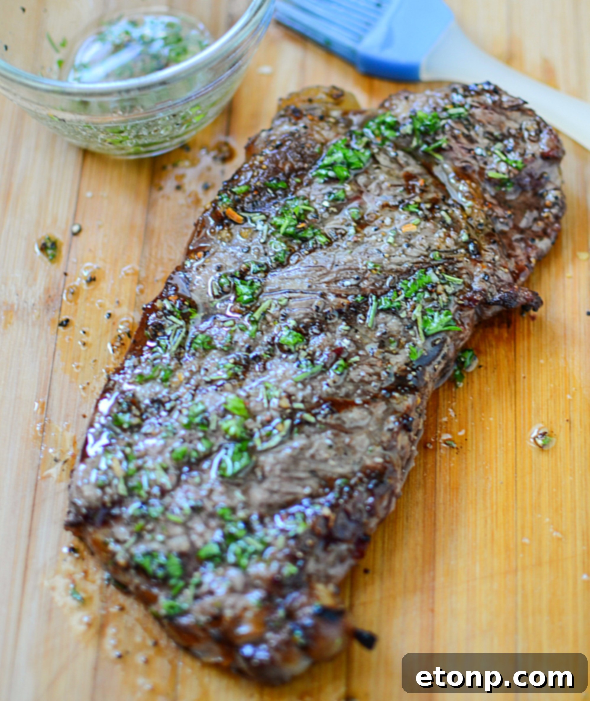 Steaks marinating in a clear plastic bag with a rich, dark marinade, ready for refrigeration.