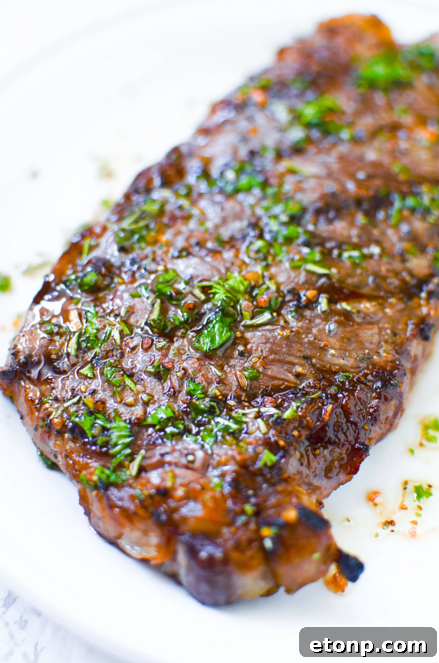 A close-up shot of a thick, juicy steak with a golden-brown crust, ready to be carved.