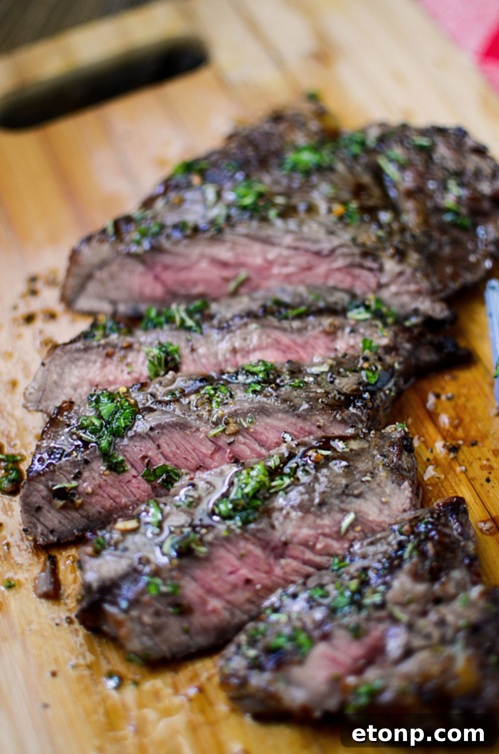 An overhead shot of a perfectly cooked steak, sliced against the grain and ready to be served, showing its tender interior.