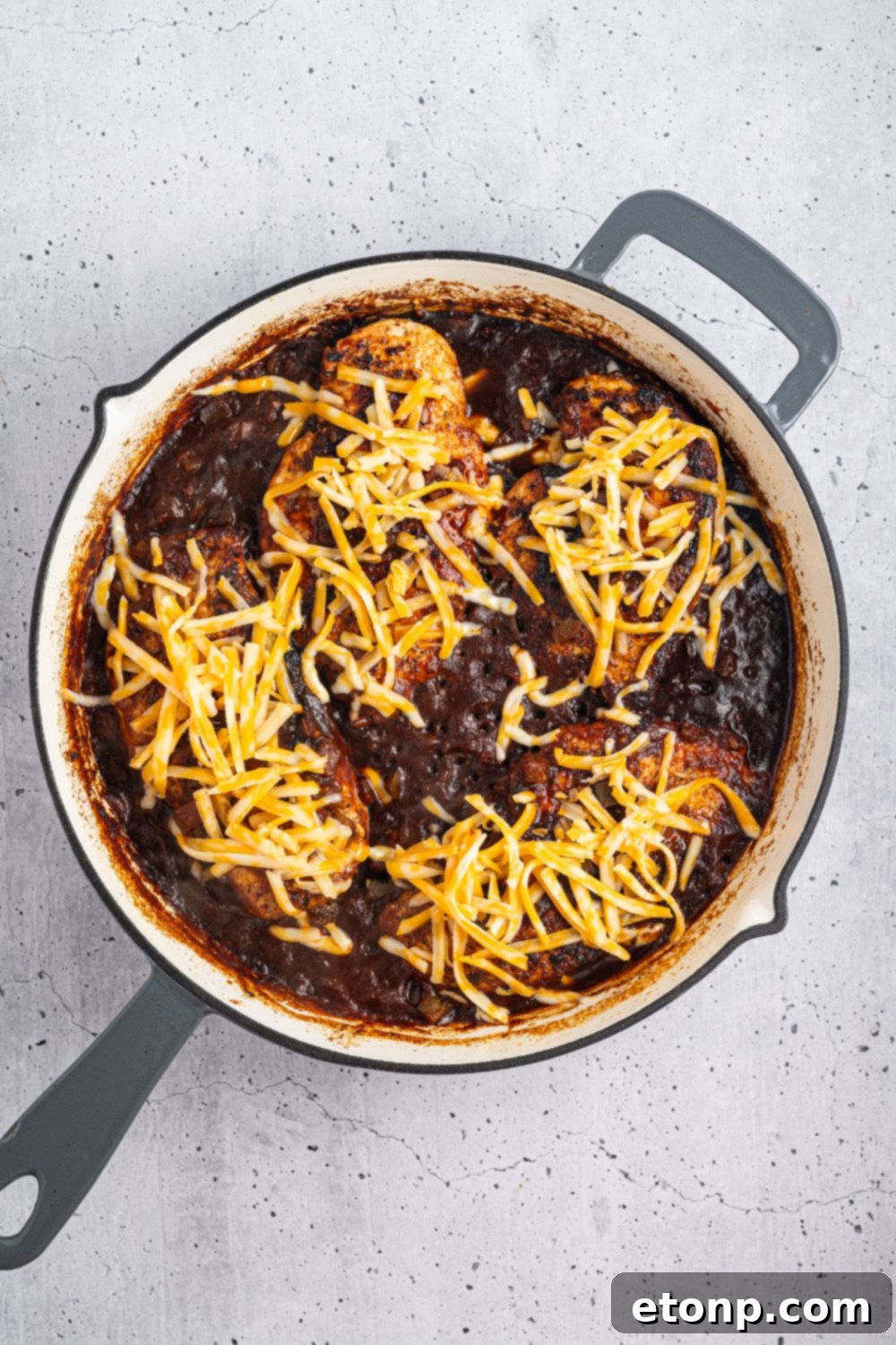One Pan Cheesy Salsa Chicken 10 saucy Cheesy Salsa Chicken in a skillet with cheese sprinkled on top