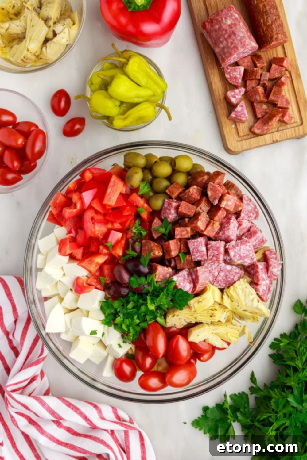A fully assembled Antipasto Tortellini Pasta Salad piled into a glass bowl, ready for serving.
