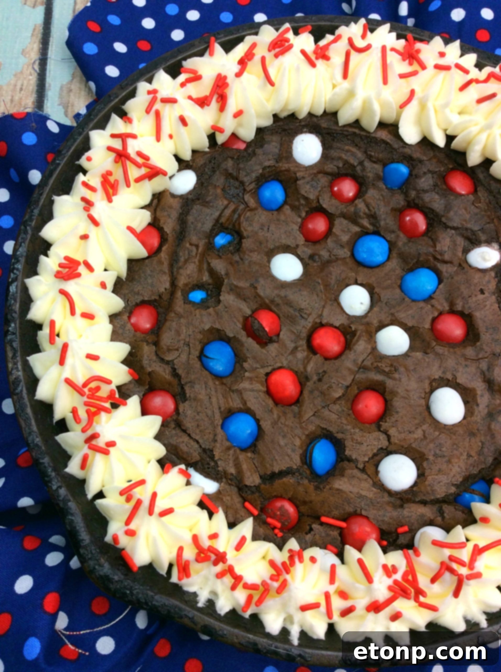 Delicious fudge brownie in a cast iron skillet topped with colorful M&Ms