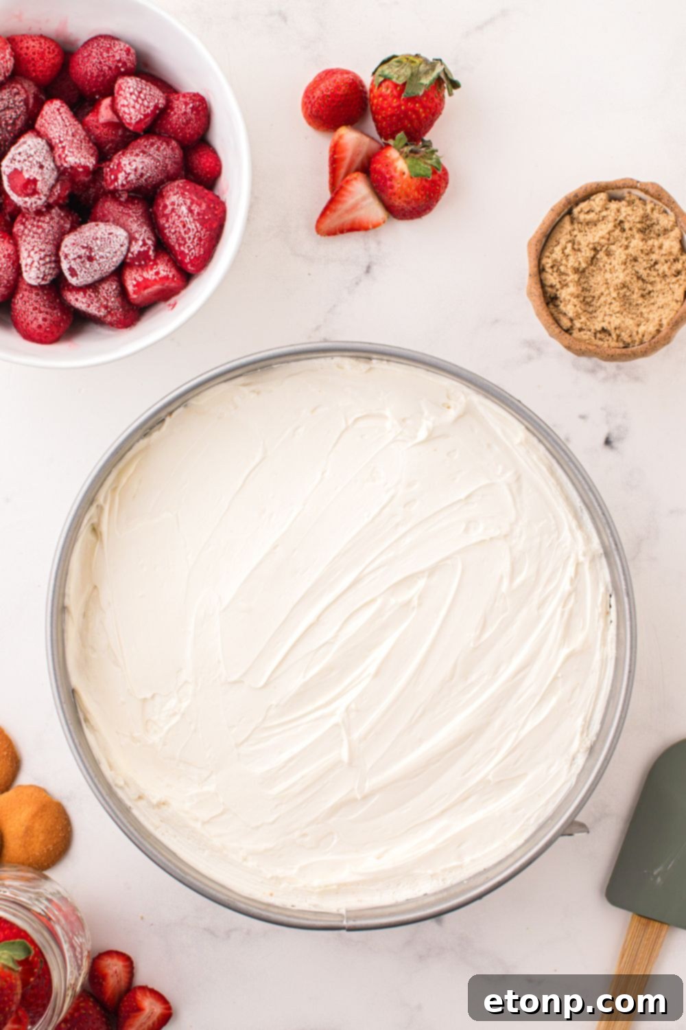 The smooth No Bake Cheesecake filling expertly spread out in a pan, showcasing its even and inviting texture before chilling.