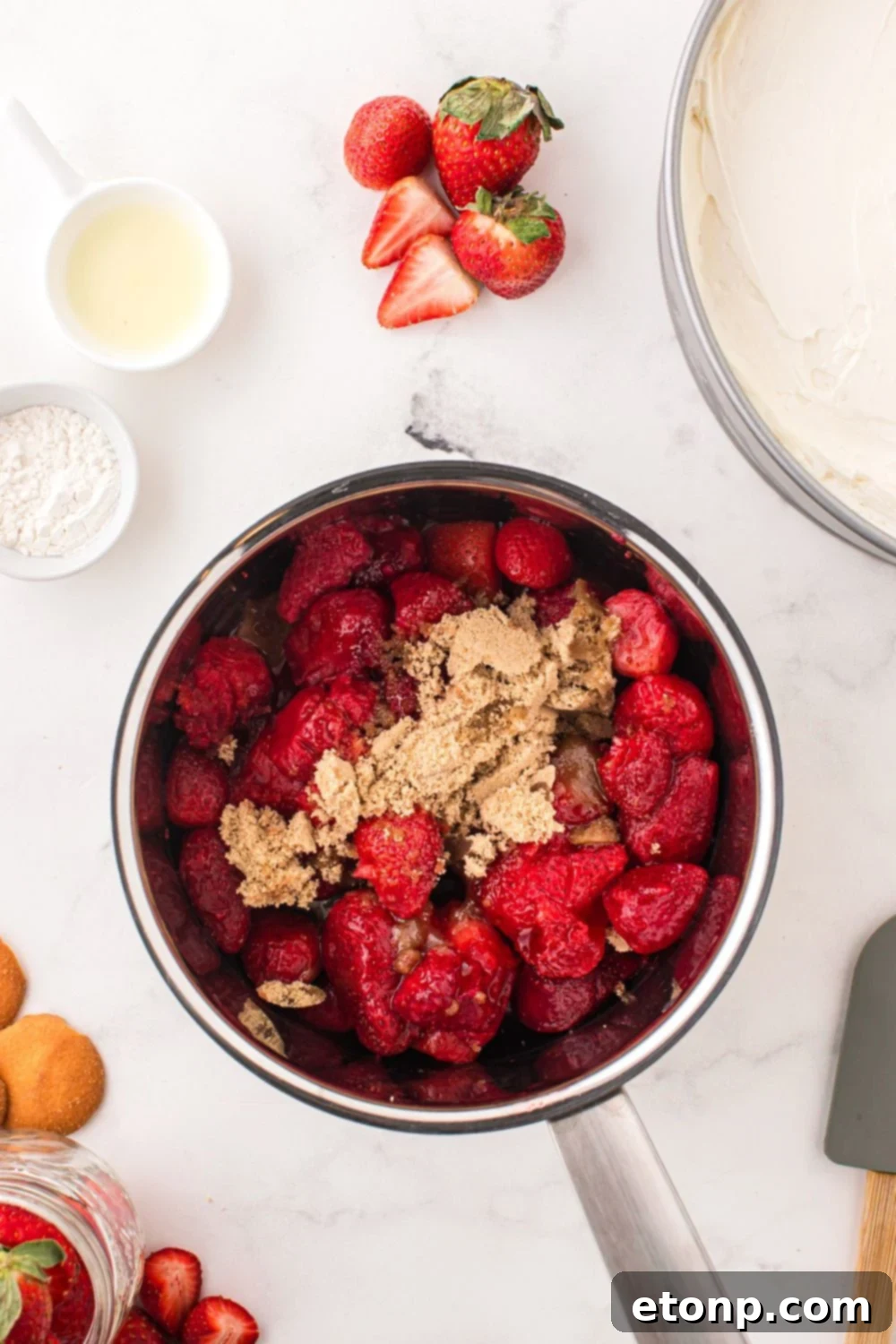 Ingredients for a luscious strawberry glaze simmering in a saucepan, beginning to transform into the vibrant topping.