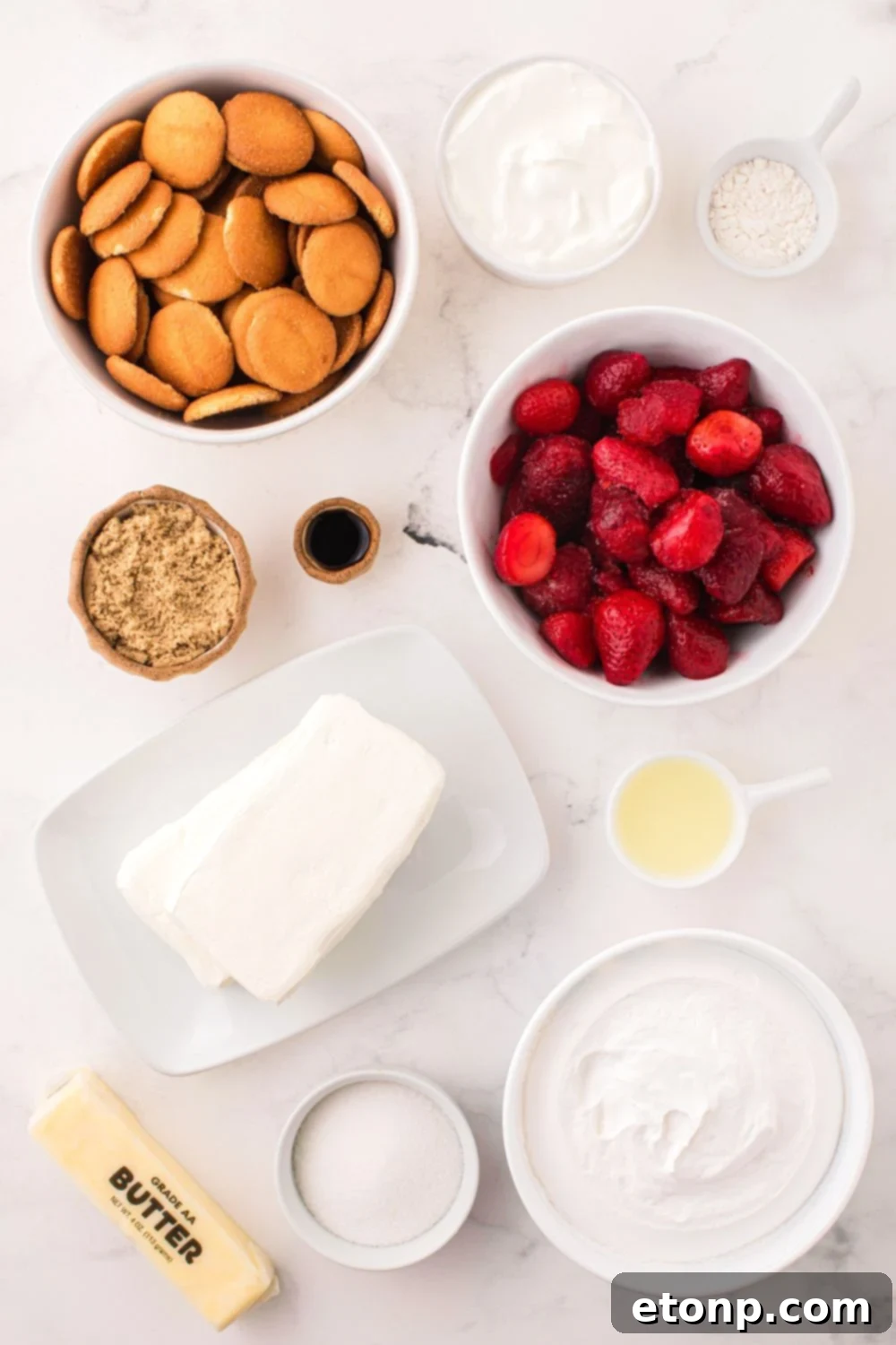 All the individual ingredients for the No Bake Strawberry Cheesecake neatly displayed in small bowls on a table, ready for preparation.