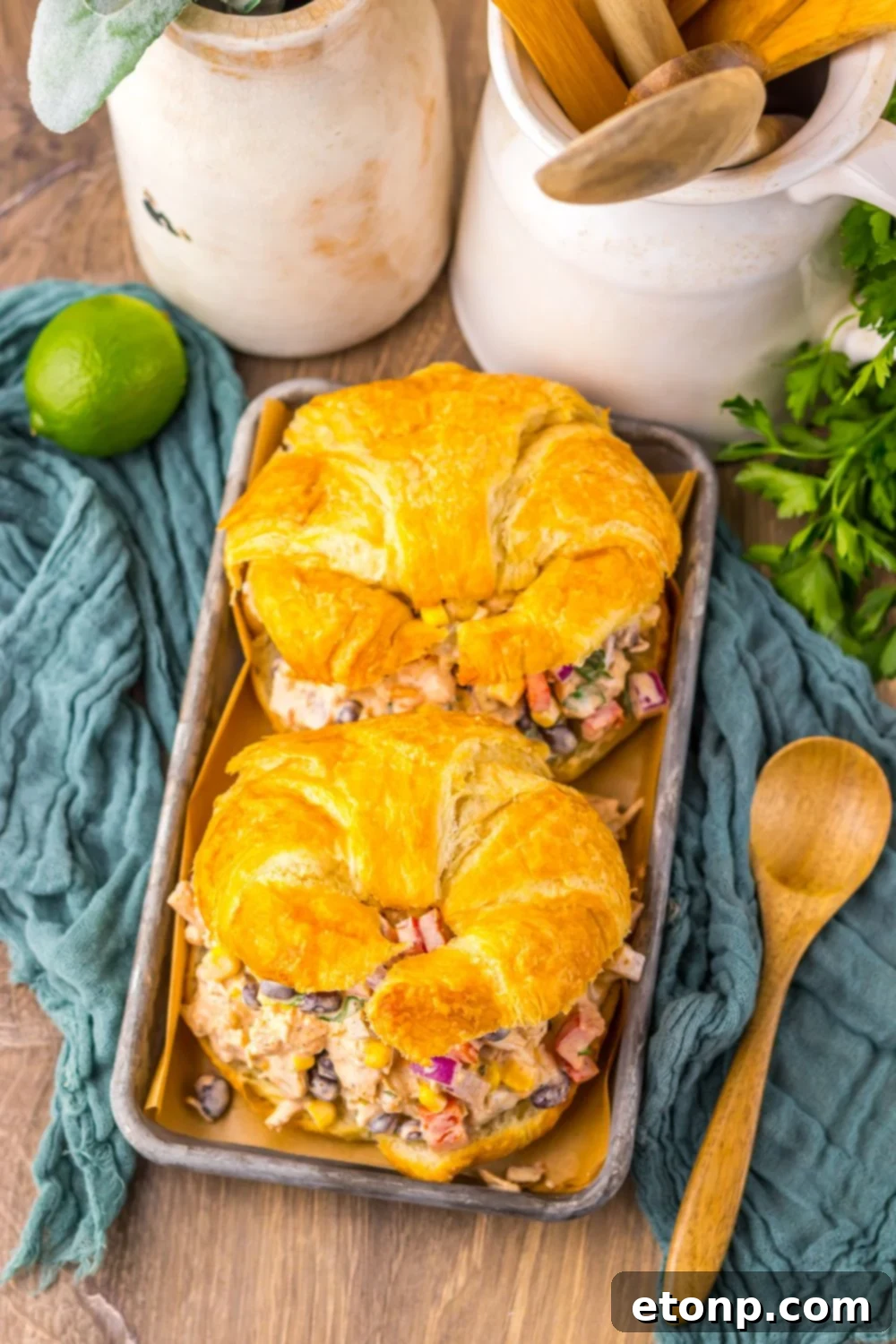 Overhead view of Creamy Taco Chicken Salad sandwiches on a table, garnished with lime and fresh cilantro.