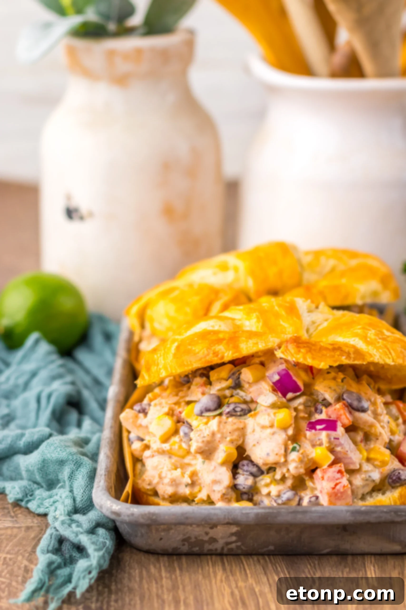 Close-up of Creamy Taco Chicken Salad served in a golden croissant on a silver platter.