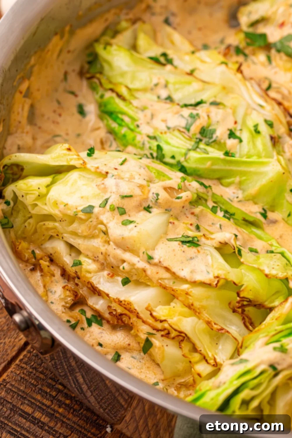 Creamy Garlic Parmesan Cabbage in a skillet with a close up look at the sauteed cabbage 