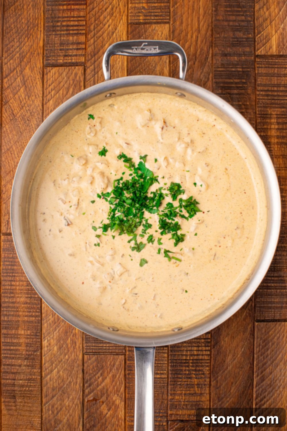 creamy garlic parmesan sauce with parsley on top of it 