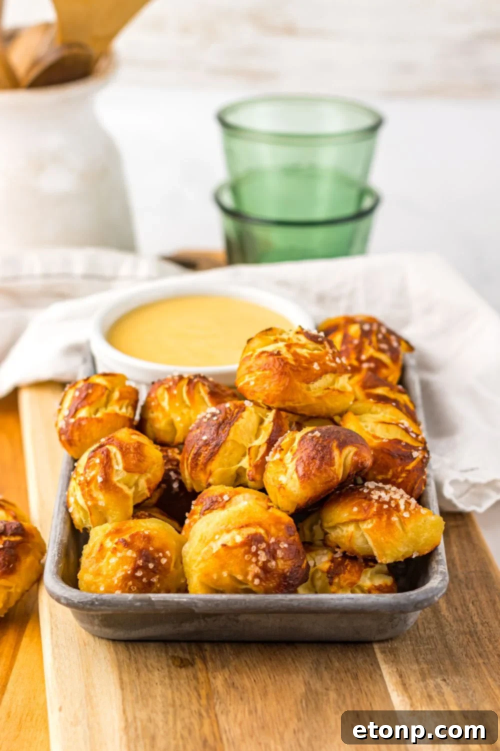 Easy Biscuit Pretzel Bites with Cheese Sauce on a tray with towel behind it on table