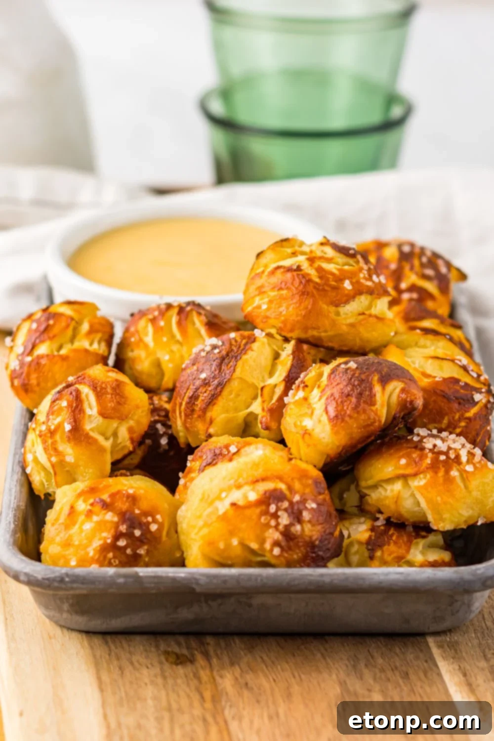 close up of Easy Biscuit Pretzel Bites with Cheese Sauce in a tray sitting on a table