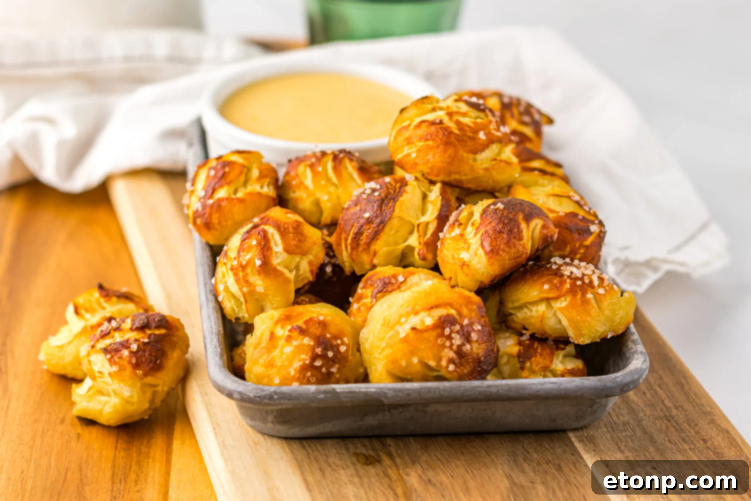 Easy Biscuit Pretzel Bites with Cheese Sauce on a tray sitting on a wooden table