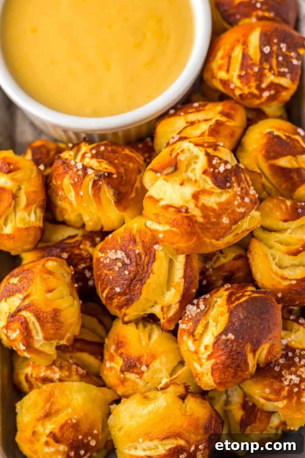 close up of Easy Biscuit Pretzel Bites with Cheese Sauce in a bowl to side