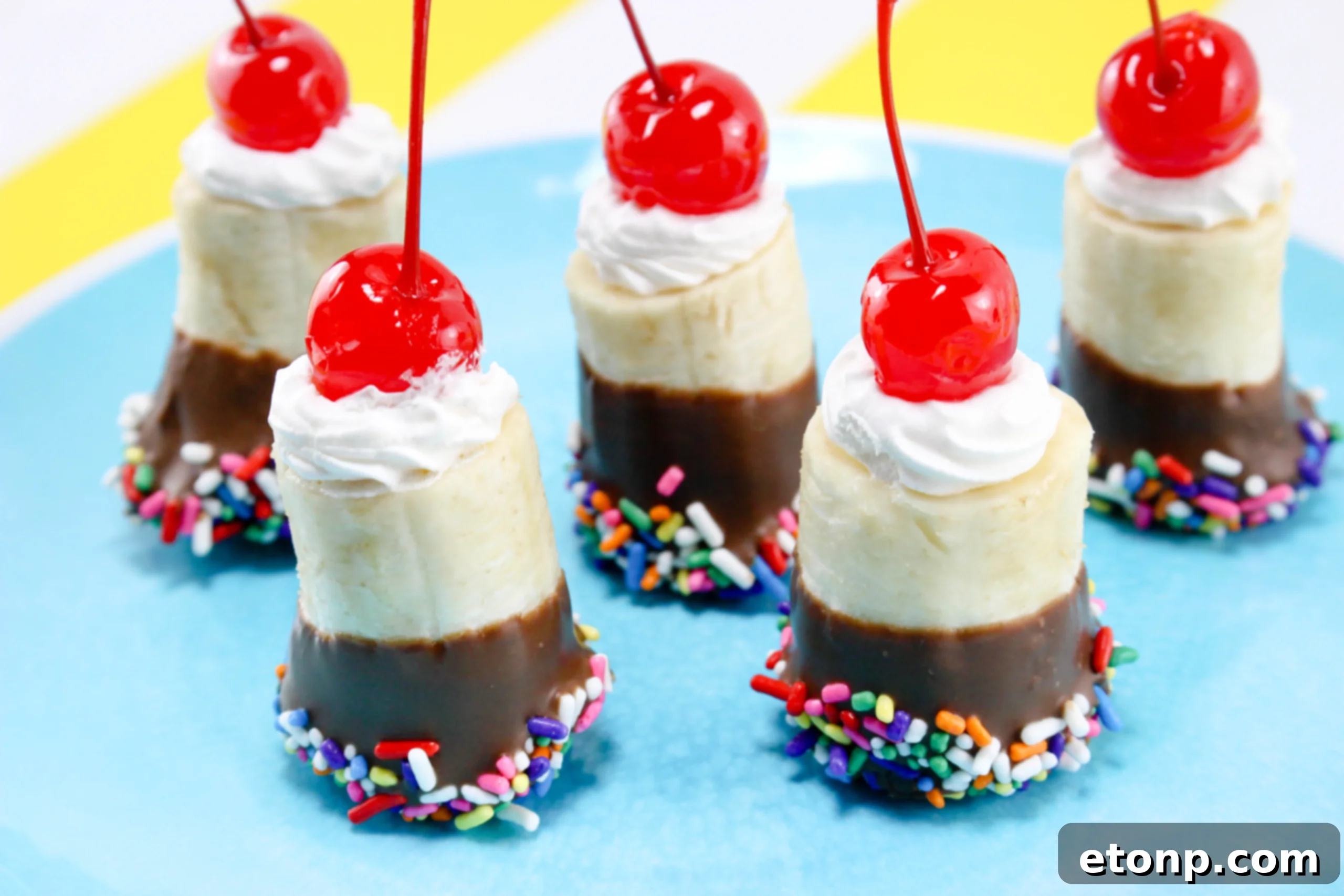 Children's hands actively participating in decorating banana split bites with sprinkles, a fun and engaging activity.