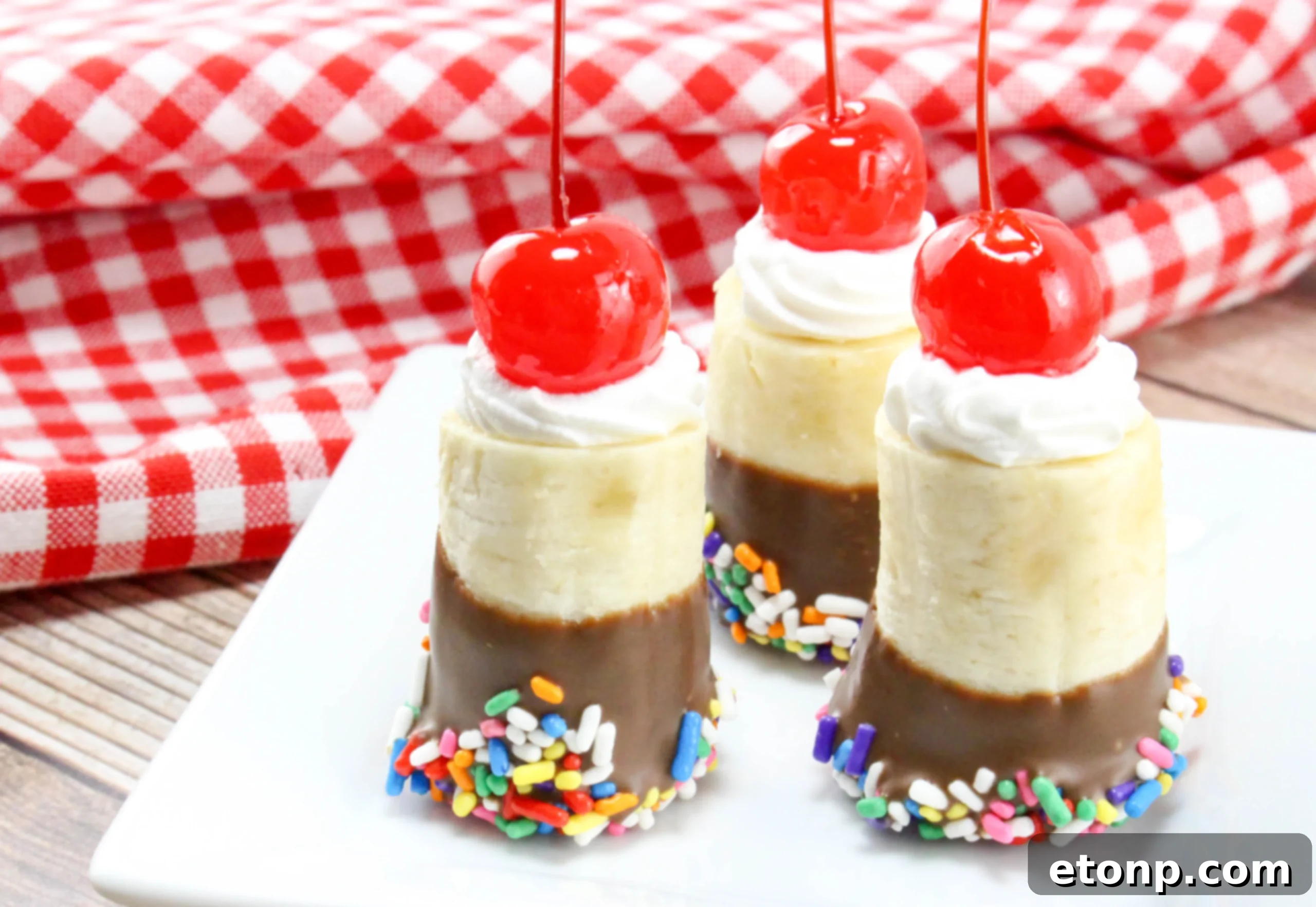 Platter of freshly made banana split bites, adorned with whipped cream, cherries, and sprinkles, ready to be served.