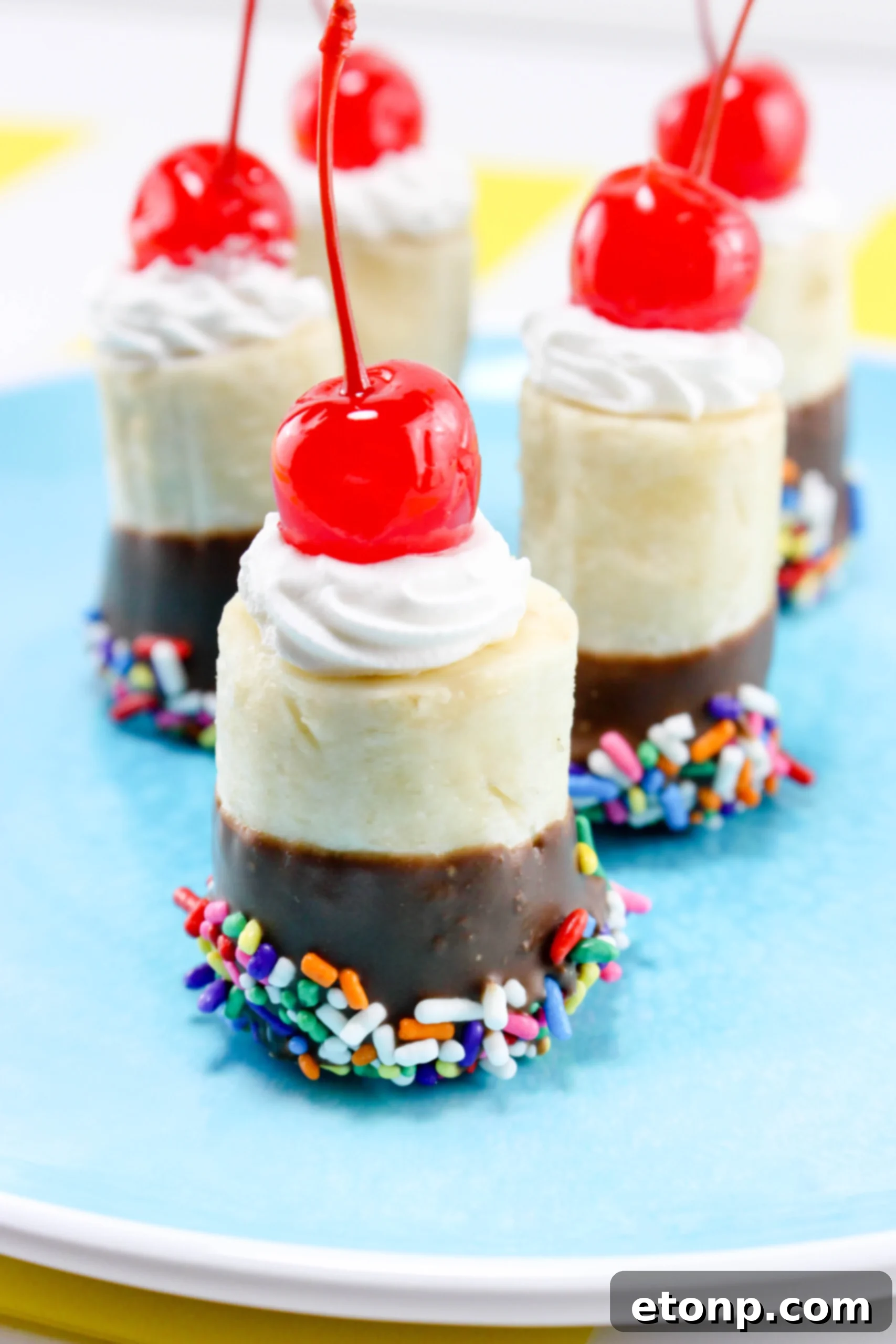 Various ingredients for banana split bites laid out, including bananas, chocolate, sprinkles, and whipped cream, highlighting the ease of preparation.