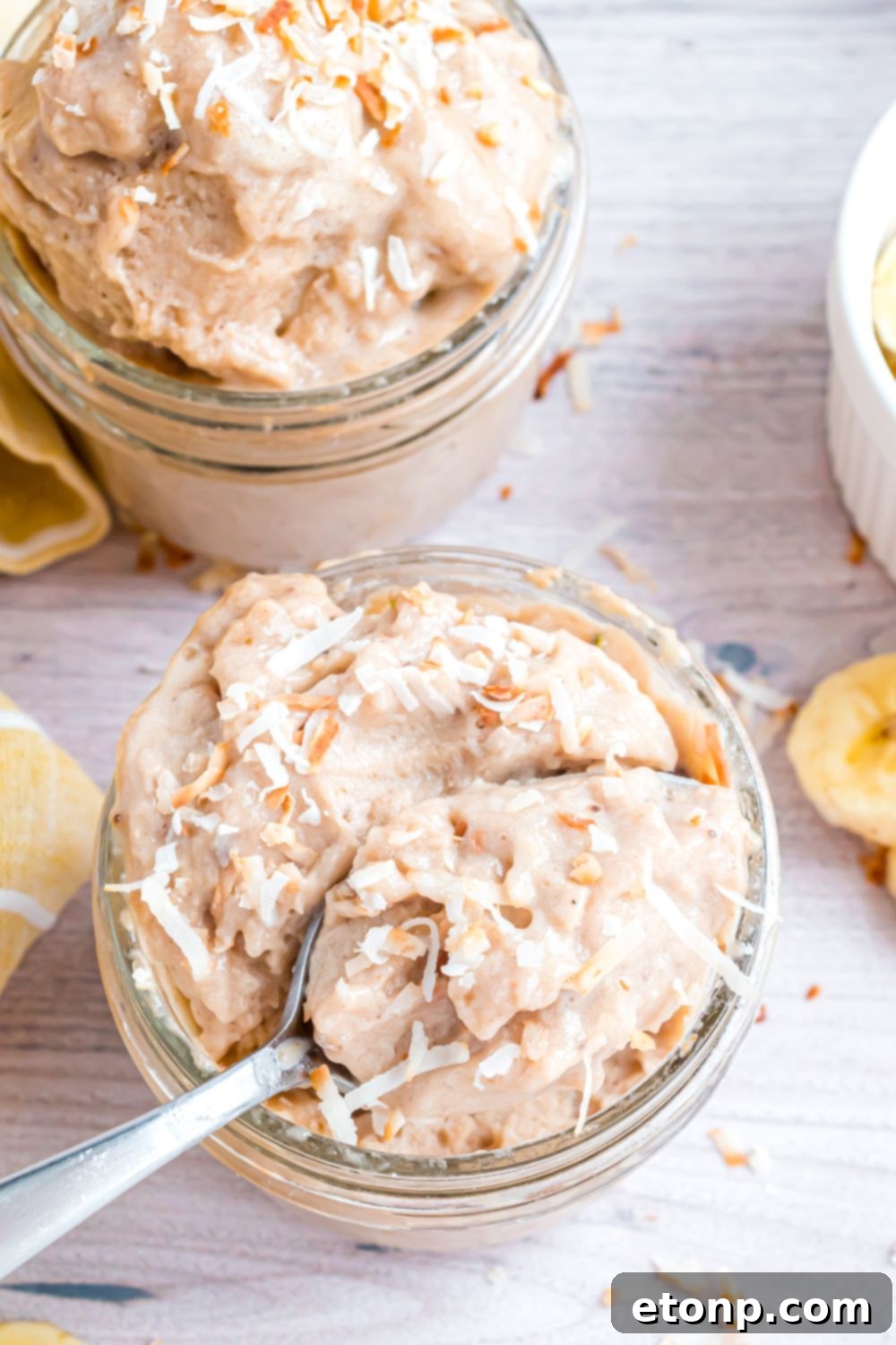 Effortless One-Ingredient Banana Ice Cream 14 Banana Ice Cream in a glass bowl with spoon inside bowl and toppings on top of ice cream