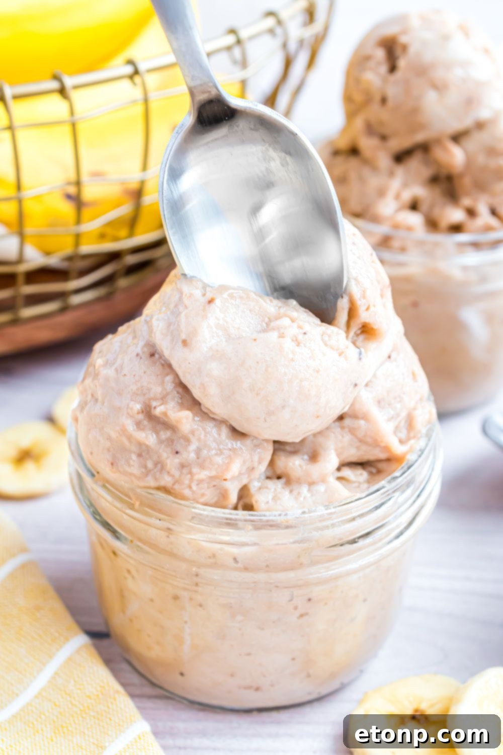 Effortless One-Ingredient Banana Ice Cream 17 glass bowl with Banana Ice Cream in it and a spoon poking inside