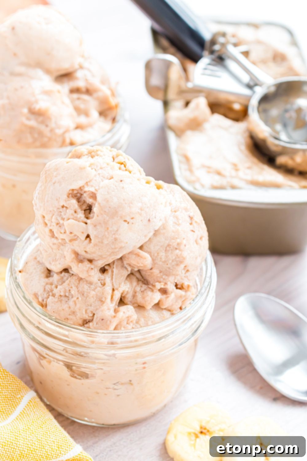 Effortless One-Ingredient Banana Ice Cream 20 Banana Ice Cream piled in containers, and then a loaf pan with the rest of ice cream inside and ice cream scoop