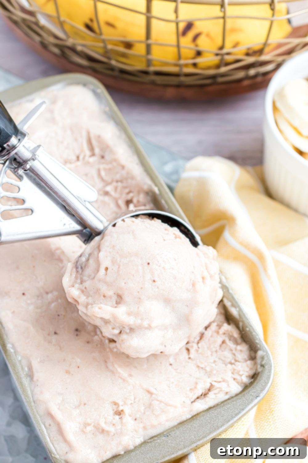 Effortless One-Ingredient Banana Ice Cream 5 Banana Ice Cream in a loaf pan with an ice cream scoop full of ice cream