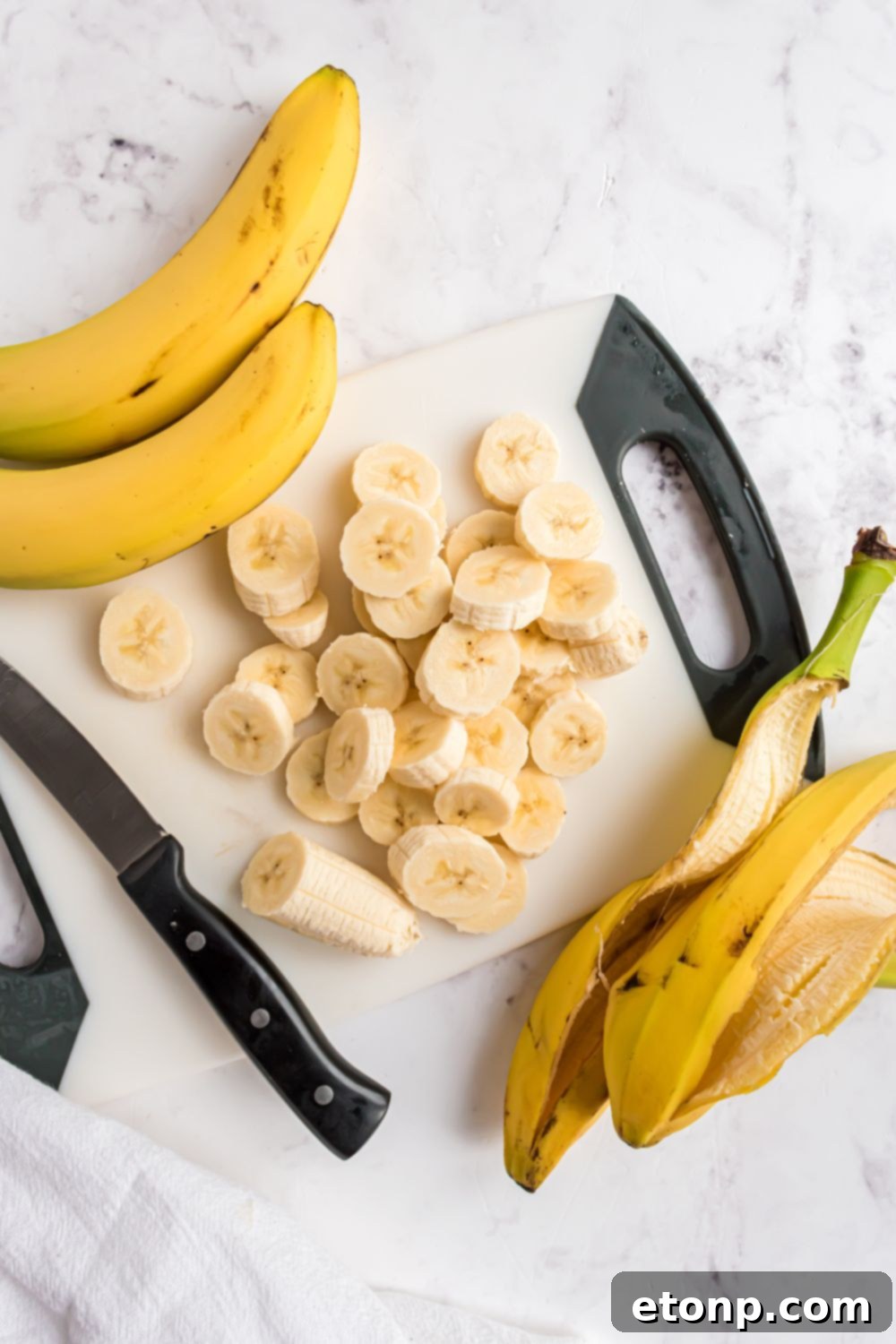 Effortless One-Ingredient Banana Ice Cream 6 bananas sliced and placed on a cutting board with peels to side for making Banana Ice Cream
