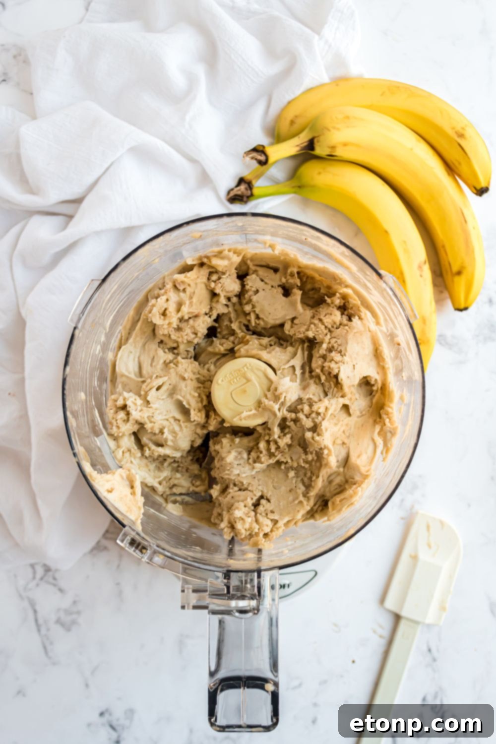 Effortless One-Ingredient Banana Ice Cream 10 Banana Ice Cream being made in a food processor with bananas to side