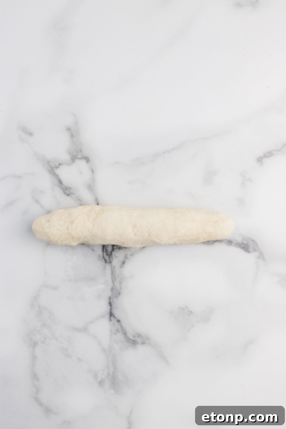 one dough ball rolled out into a snake 