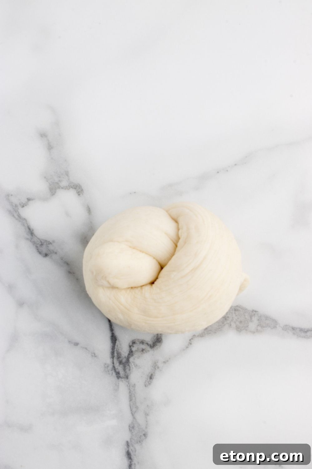 rolling dough into a knot sitting on table 