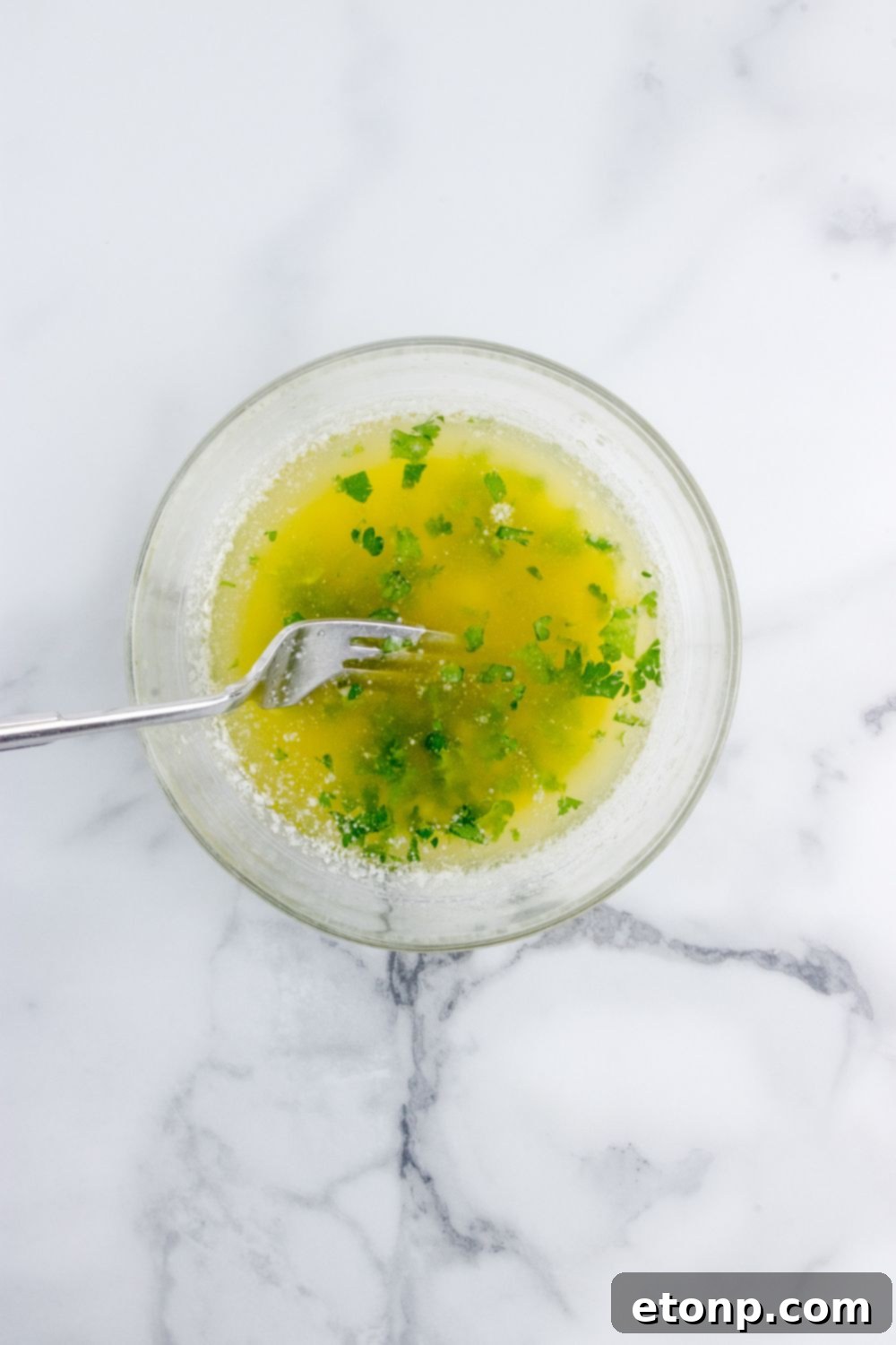 bowl of garlic butter sauce with fork in it 