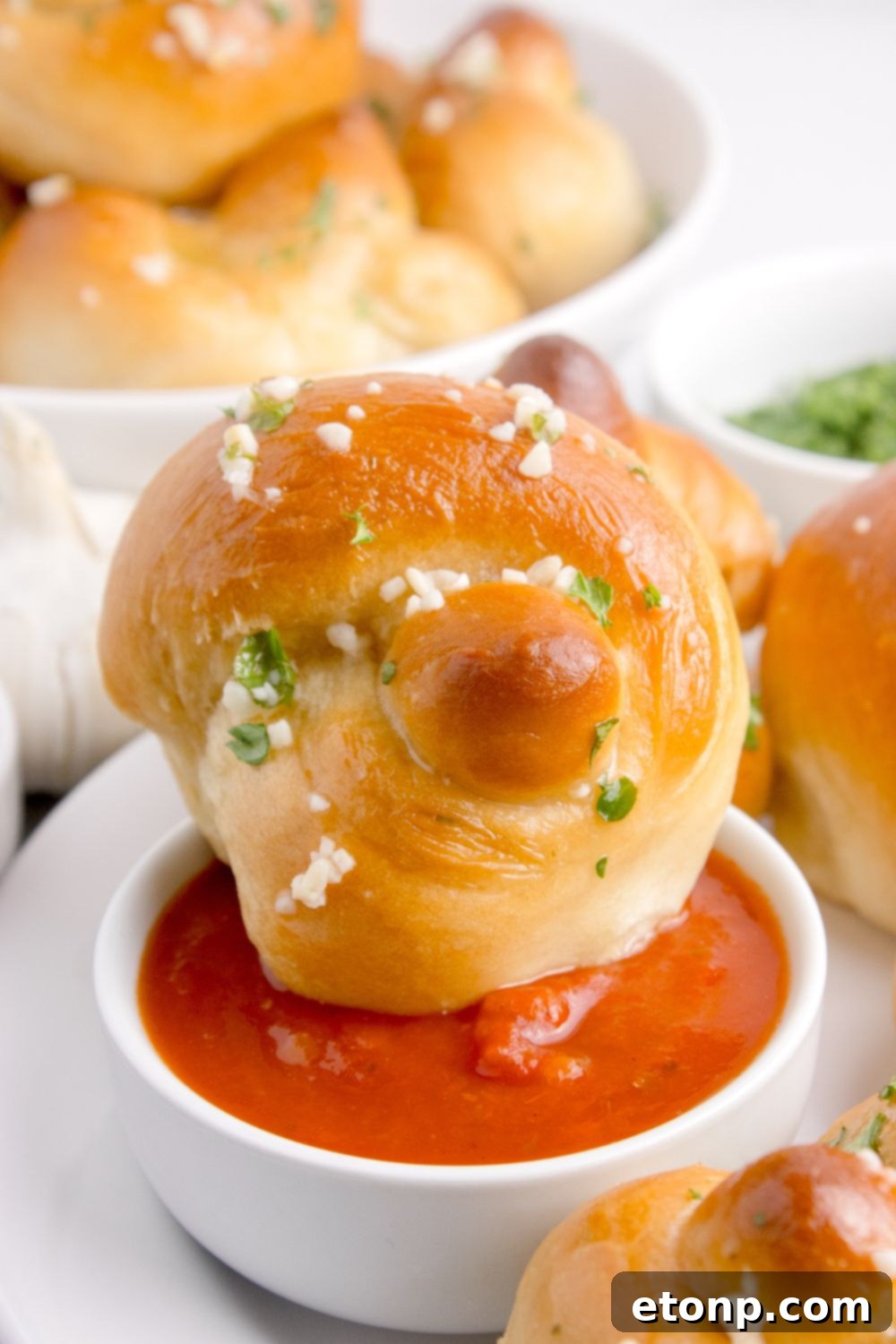 garlic knots dipped in marinara sauce sitting on table 