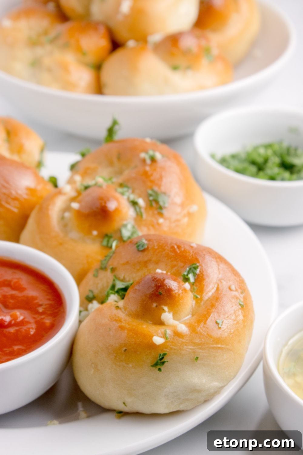 plate with Homemade Garlic Knots with a bowl of sauce to side 
