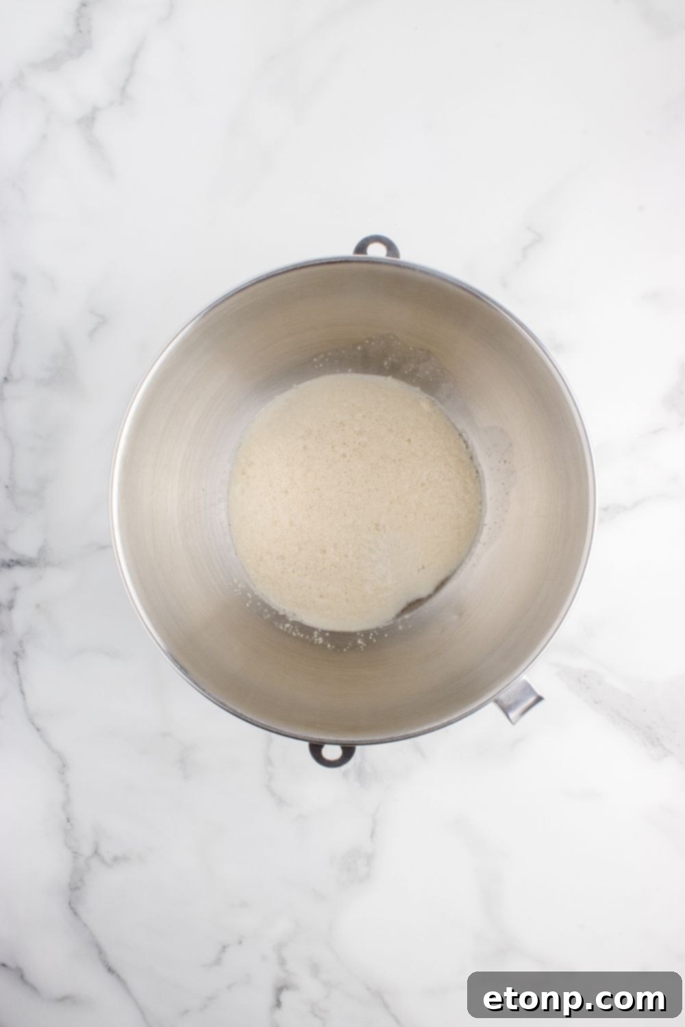 yeast mixture in a metal bowl on table 