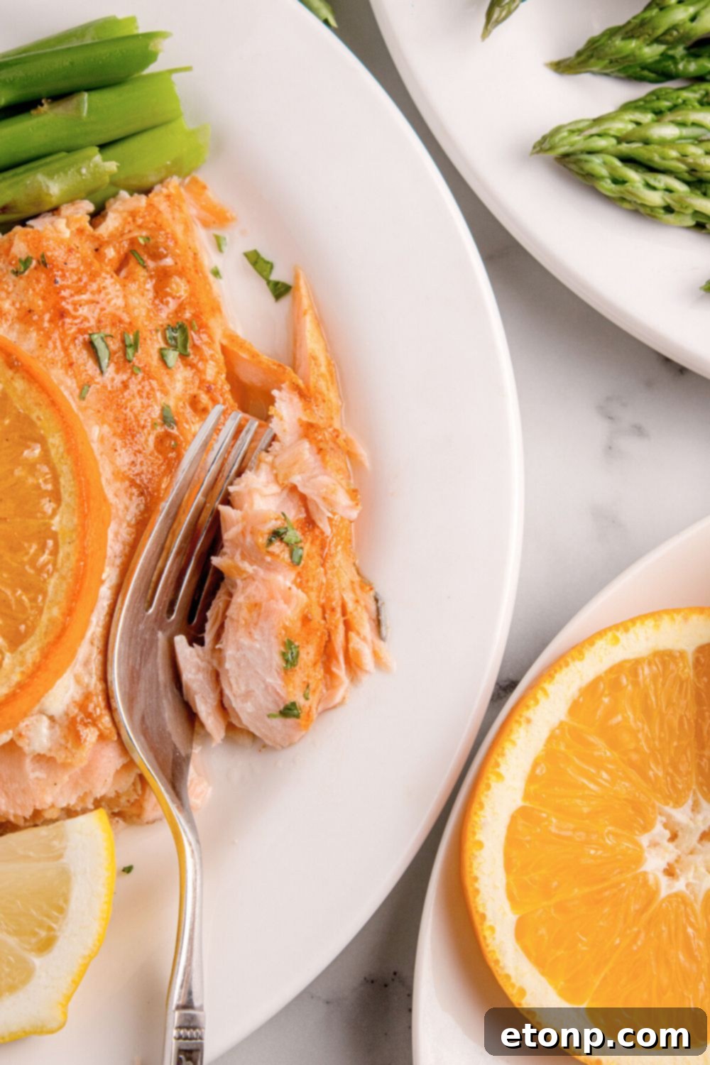 Simple Grilled Honey Mustard Salmon Foil Packets 13 Grilled Honey Mustard Salmon on plate with a fork biting into a piece of it with asparagus on a second plate